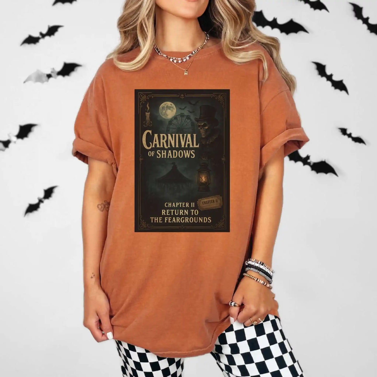 Person wearing a yam colored t-shirt with 'Carnival of Shadows' design, standing against a white background with black bats.