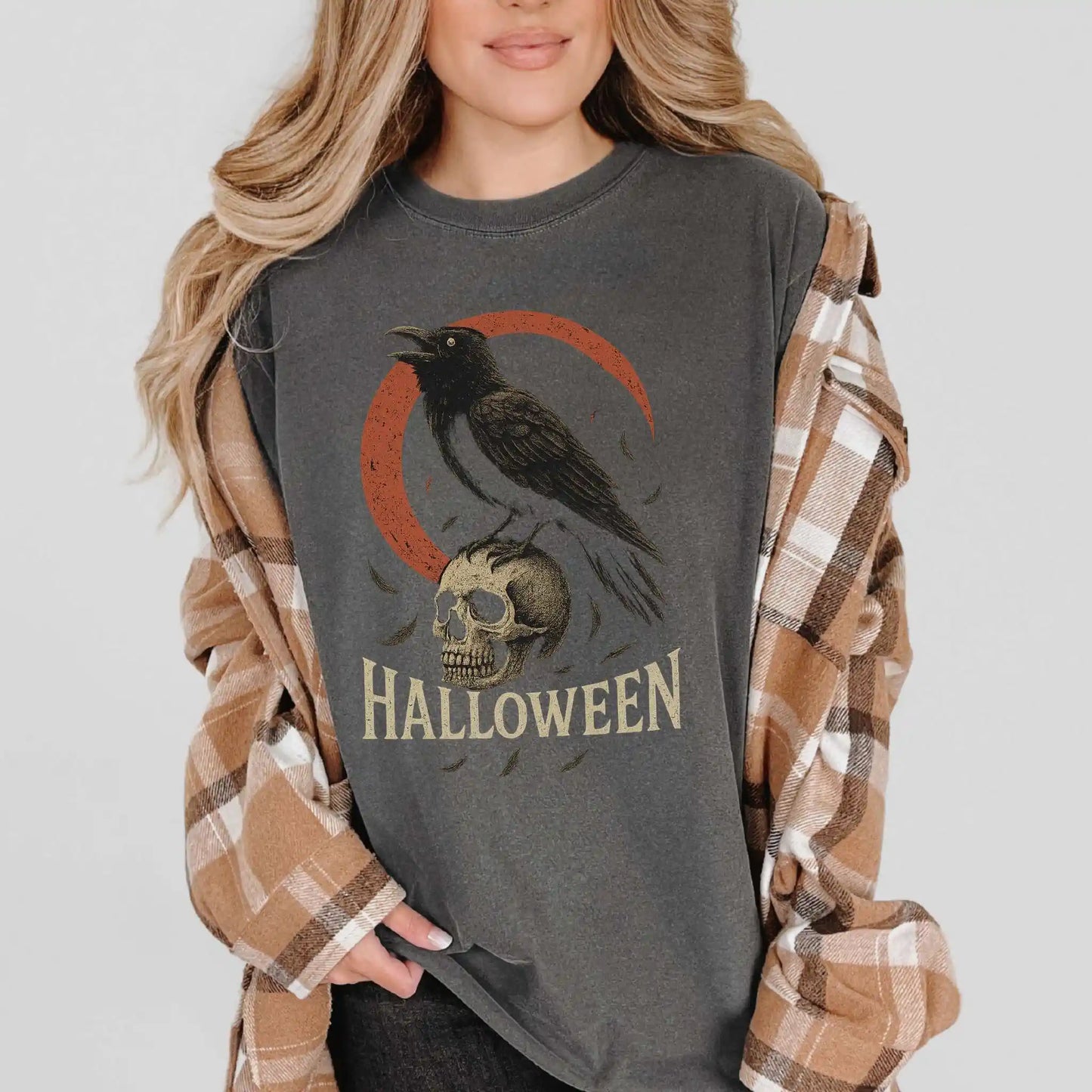 Person wearing a Halloween-themed shirt with a crow and skull design.