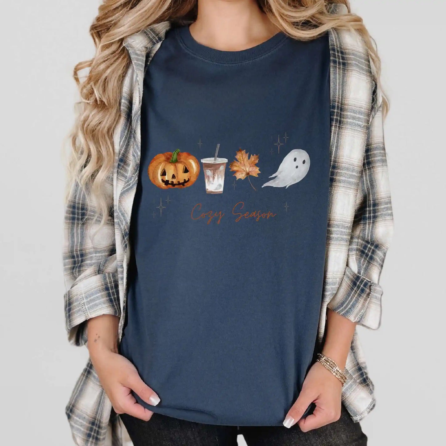Person wearing a navy blue t-shirt with Halloween-themed graphics and 'Cozy Season' text.