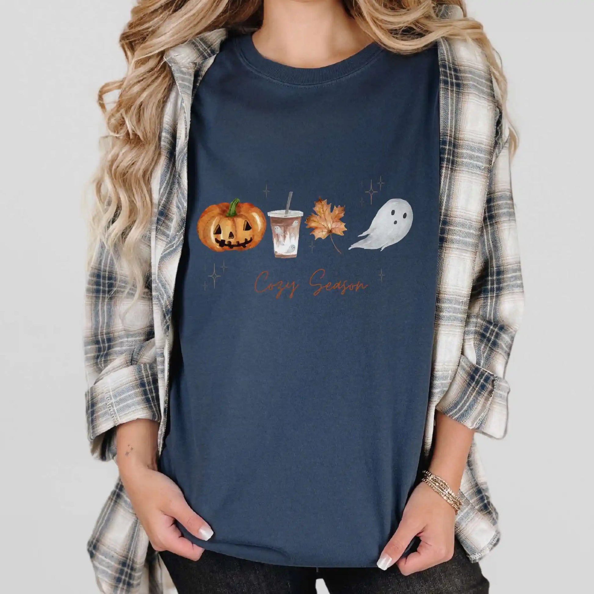 Person wearing a navy blue t-shirt with Halloween-themed graphics and 'Cozy Season' text.