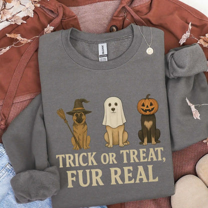 Gray sweatshirt with Halloween-themed design featuring dogs in costumes and text 'Trick or Treat, Fur Real' on a textured surface.