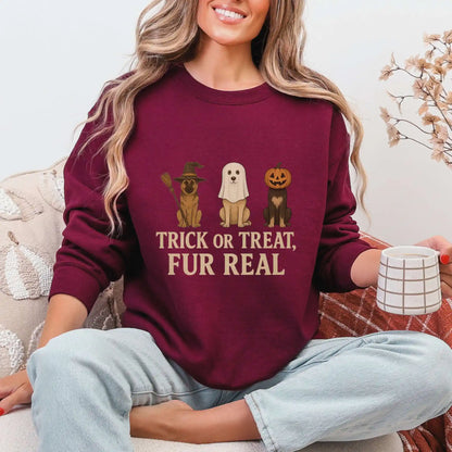 Woman wearing a maroon sweatshirt with Halloween-themed dog graphics and "Trick or Treat, Fur Real" text, sitting on a couch.