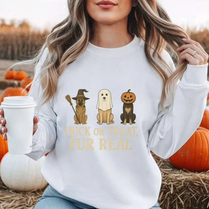 Person wearing a white sweatshirt with Dog Halloween-themed graphics and "Trick or Treat Fur Real" text, holding a coffee cup in an outdoor setting with pumpkins.