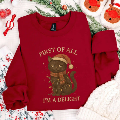 Red sweatshirt with a cat christmas-themed graphic and "First of all I'm a delight" text on a festive background