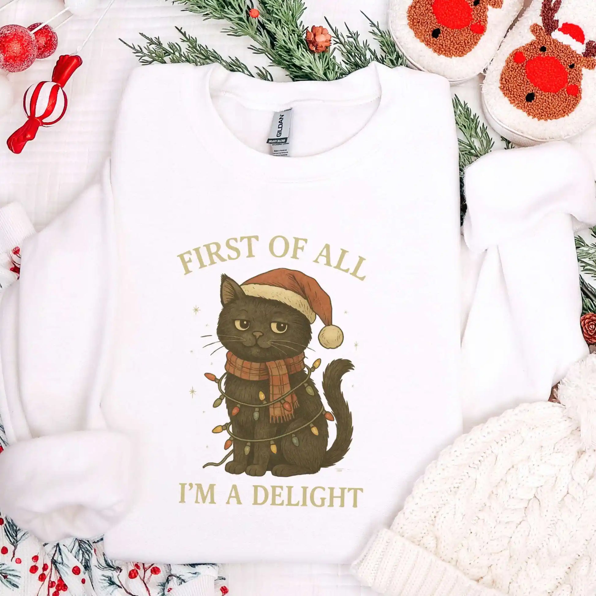 White sweatshirt with a Christmas-themed design of a cat wearing a Santa hat and scarf, surrounded by festive decorations.