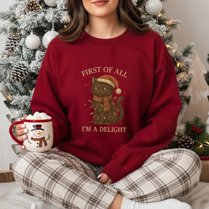 Person wearing a red sweater with a Cat Christmas-themed design, sitting in front of a decorated tree.
